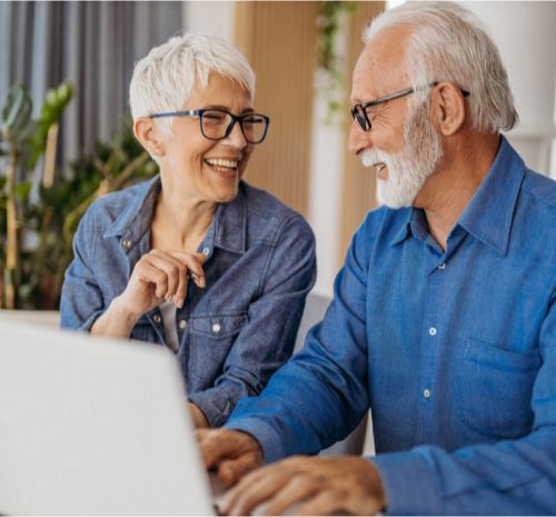 Older couple sitting at laptop together