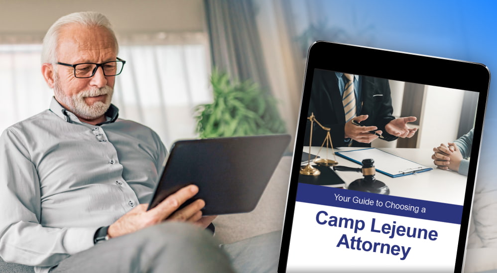Older man looking at an Ipad that reads 'Your Guide to Choosing a Camp Lejeune Attorney'