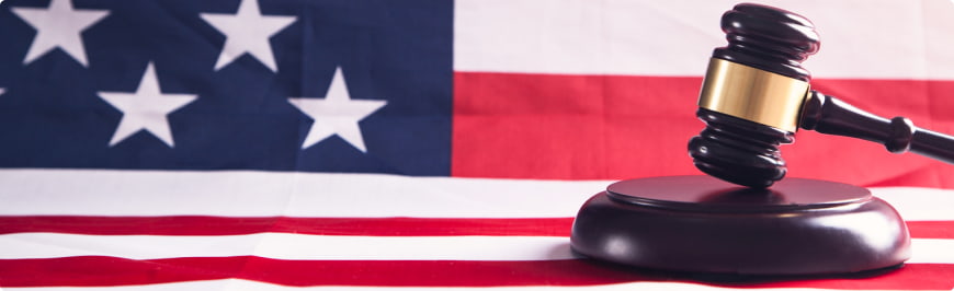 A gavel and block in front of the American flag.